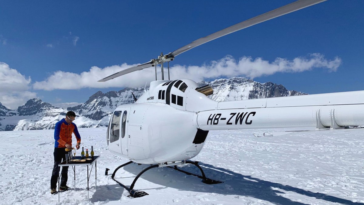 a group of people standing around a plane on the snow