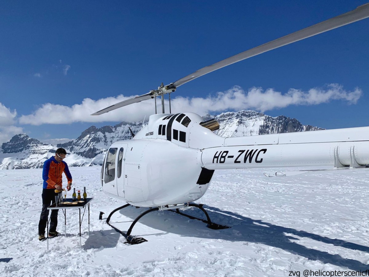 a group of people standing around a plane on the snow