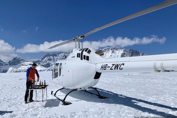 a group of people standing around a plane on the snow
