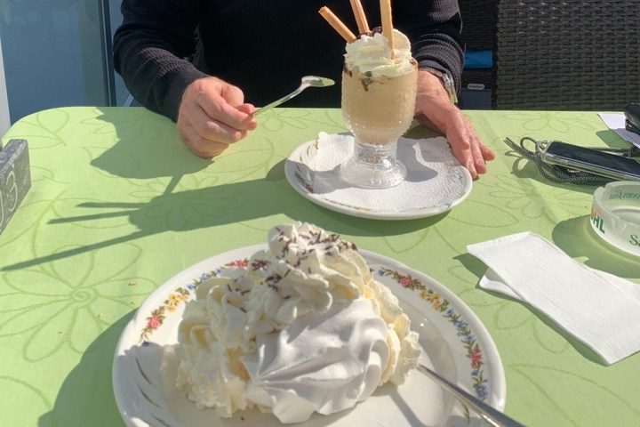 a woman sitting at a table with a cake on a plate