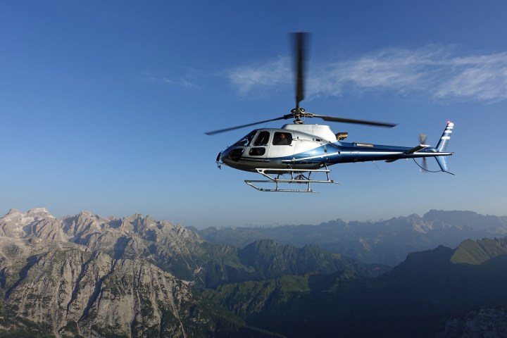 Helicopter flying from right to left over the Swiss Alps at sunset on a warm summer evening.